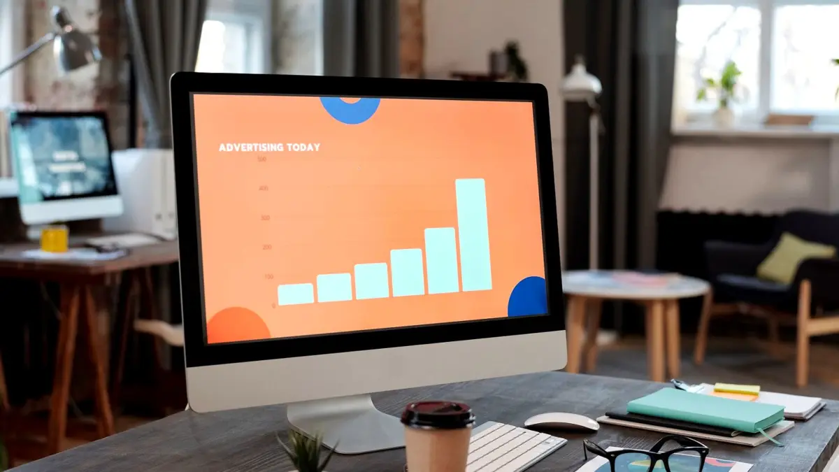 Monitor na biurku z wykresami wyników kampanii reklamowej