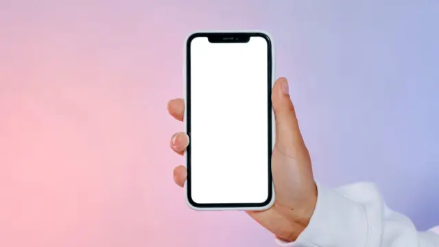 Zbliżenie na dłoń trzymającą smartfon z pustym ekranem