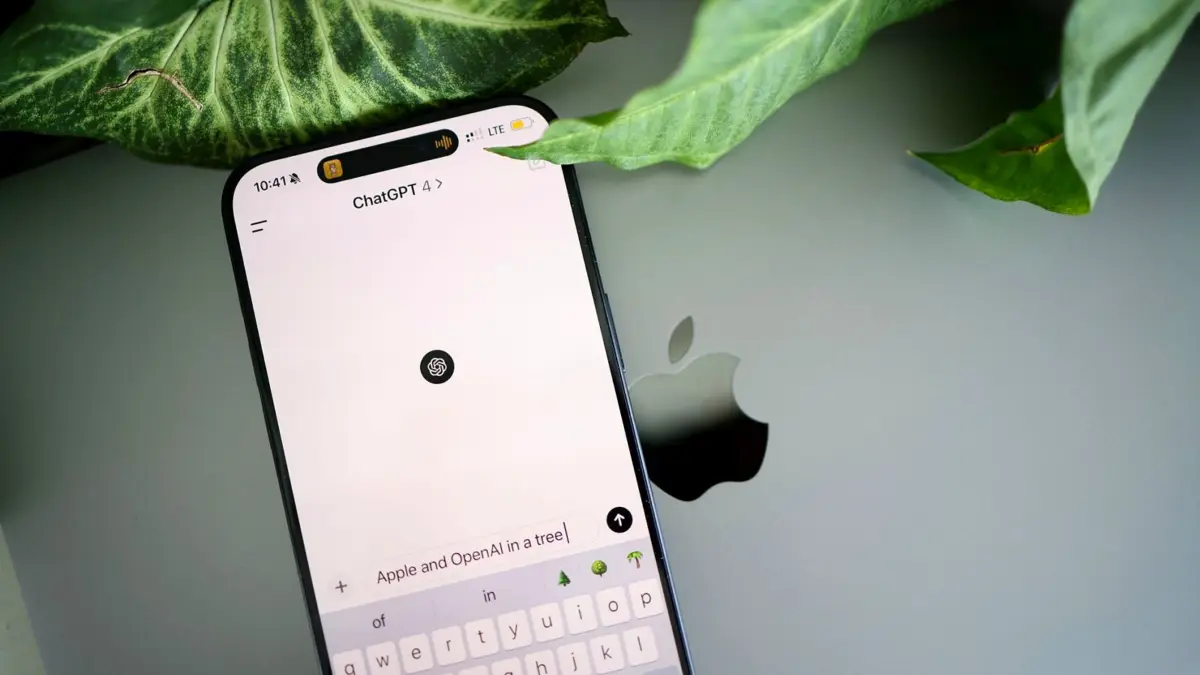 Smartfon z otwartą aplikacją ChatGPT leżący na klawiaturze laptopa.