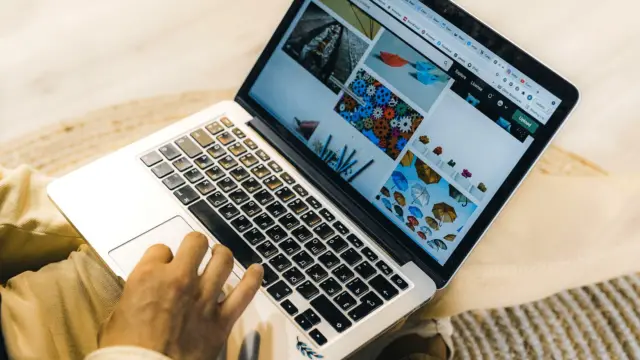 Osoba przy laptopie przegląda propozycje produktów w oknie czatu, obok stoi kubek kawy.