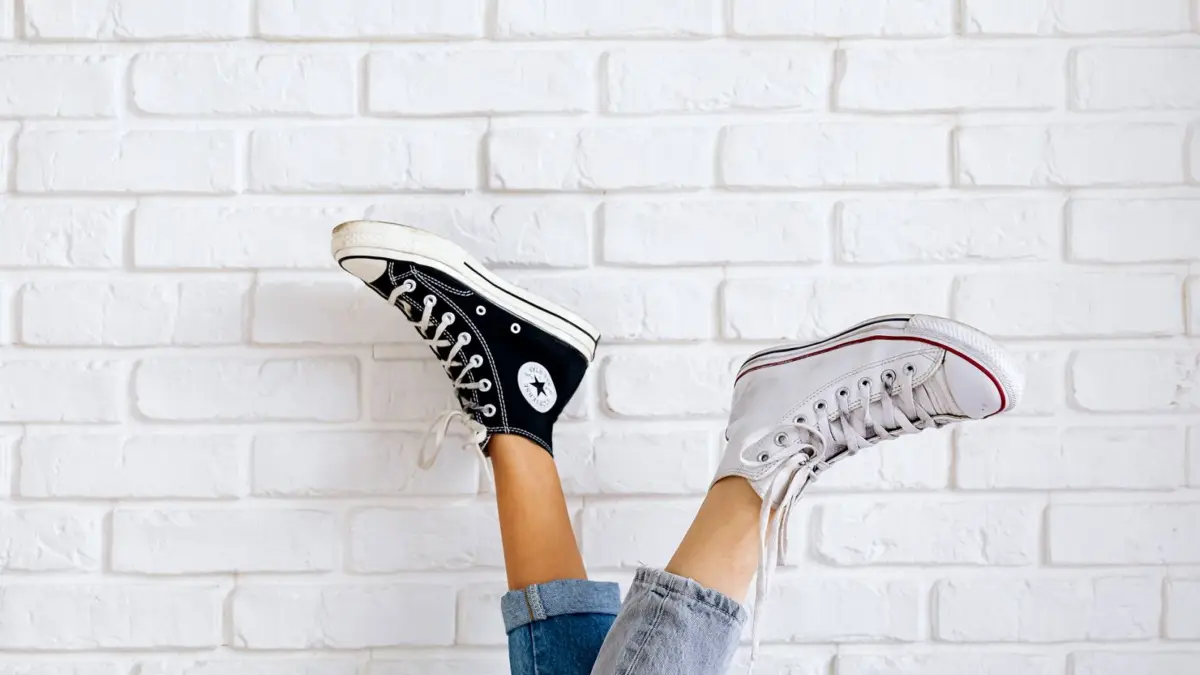 Dwie pary trampek Converse przy białej ceglanej ścianie
