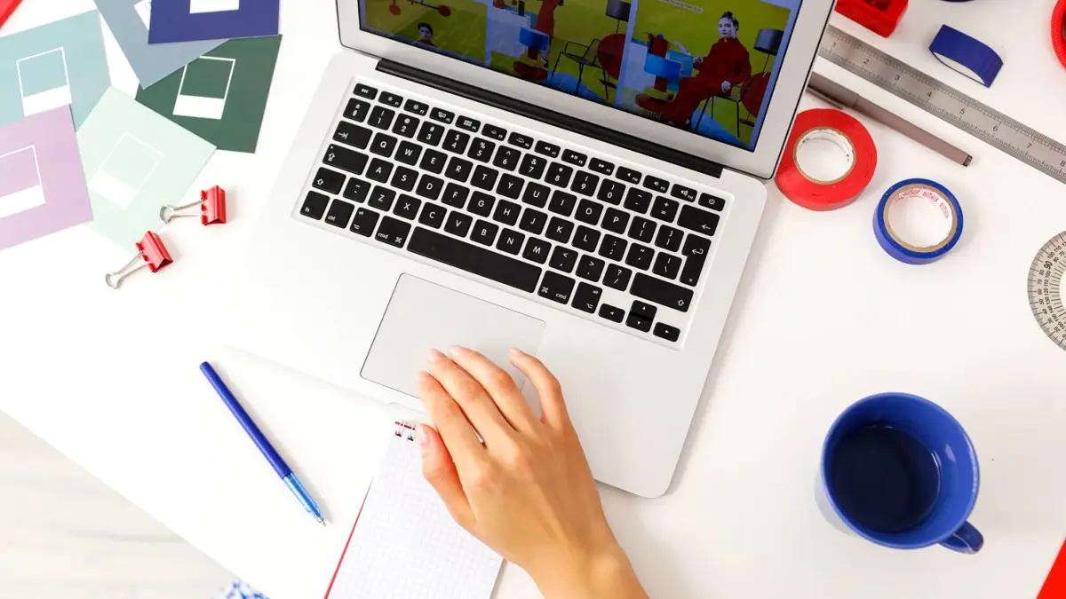 Biurko w agencji kreatywnej: laptop, notes i przybory do pracy nad projektem.