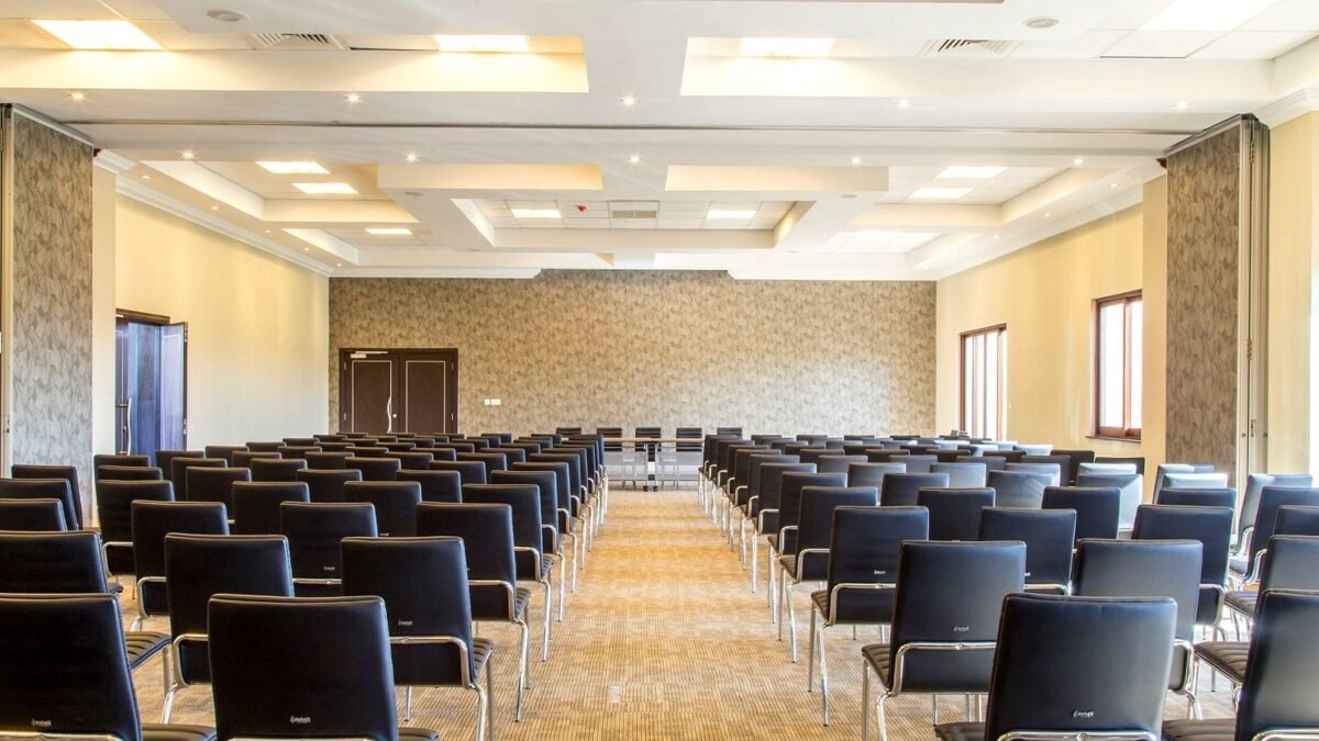 Pusta sala konferencyjna z nowoczesnym wyposażeniem i równo ustawionymi krzesłami.