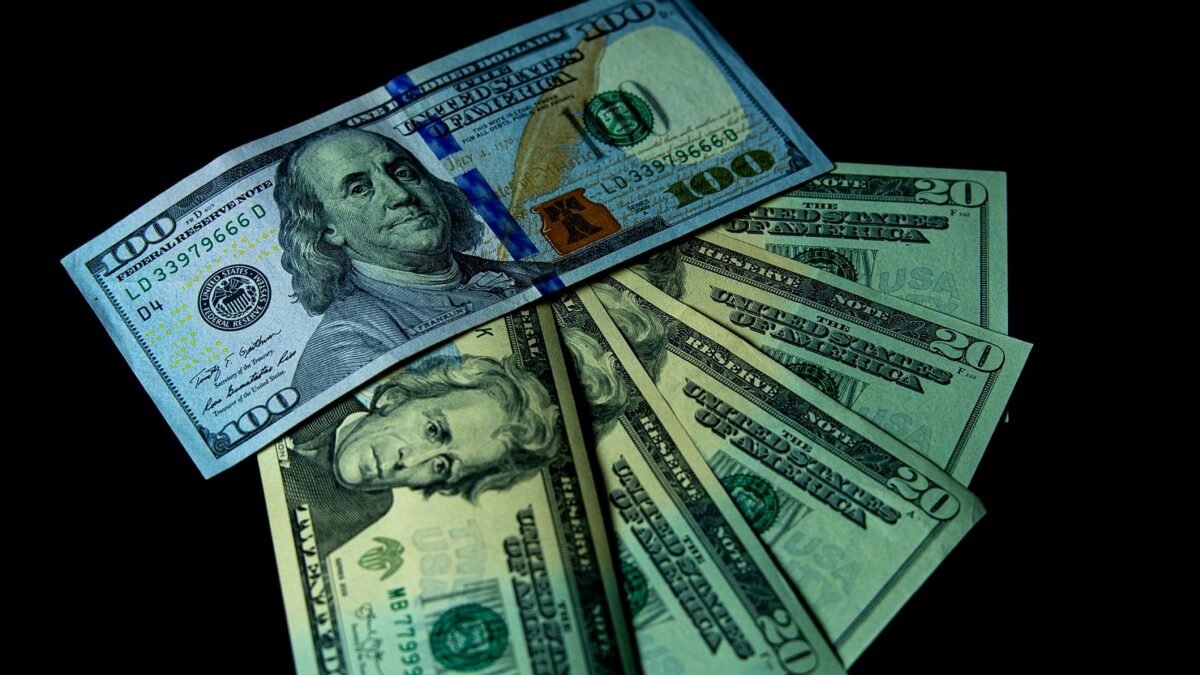 Banknoty dolarowe rozłożone na blacie stołu
