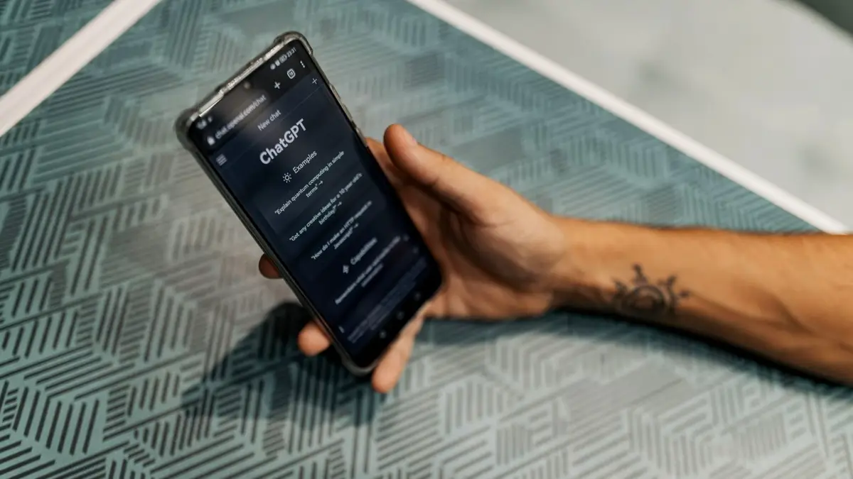 Dłoń trzymająca smartfon z otwartą rozmową w ChatGPT