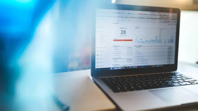 Laptop z otwartym panelem Google Analytics, który pokazuje ruch na stronie na żywo