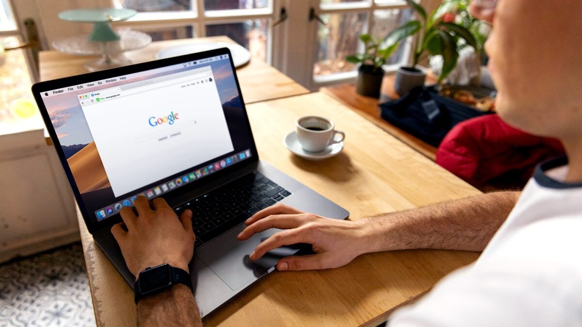 Osoba przegląda wyniki wyszukiwania Google na laptopie przy jasnym biurku