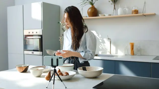 Kobieta nagrywa telefonem film kulinarny w kuchni