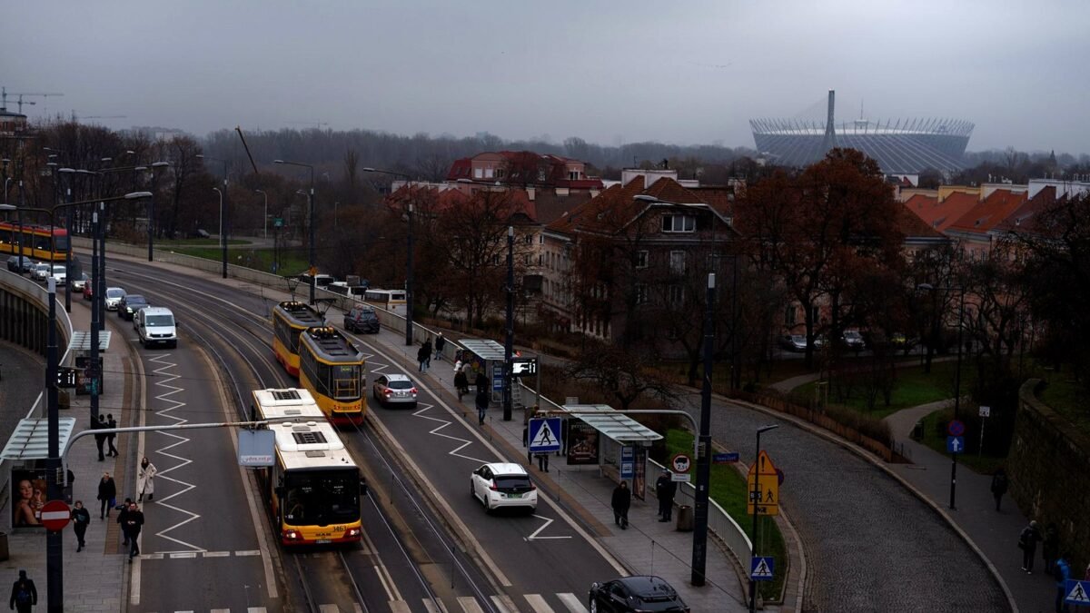 Ruchliwa ulica w Warszawie z tramwajami, samochodami i przechodniami