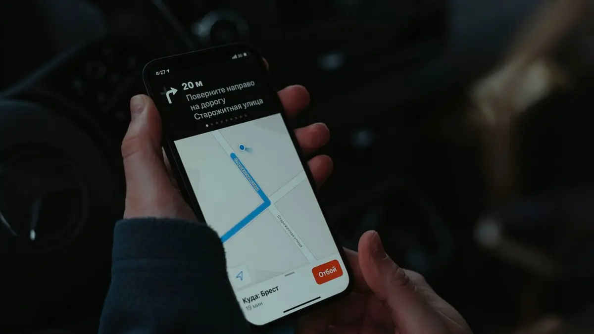 Zbliżenie na smartfon w dłoni z otwartą mapą i wskazówkami dojazdu