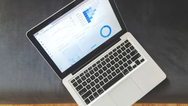 Laptop na biurku z otwartym pulpitem analitycznym i wykresami ruchu