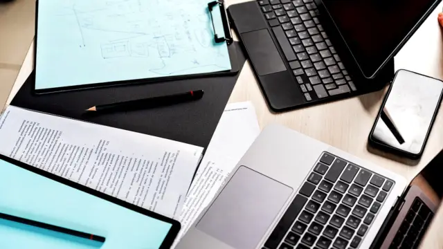 Biurko z laptopami, tabletem i dokumentami widziane z góry