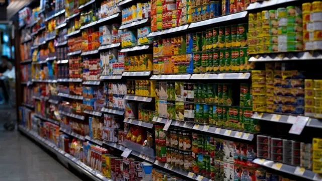 Alejka w supermarkecie z puszkami na półkach