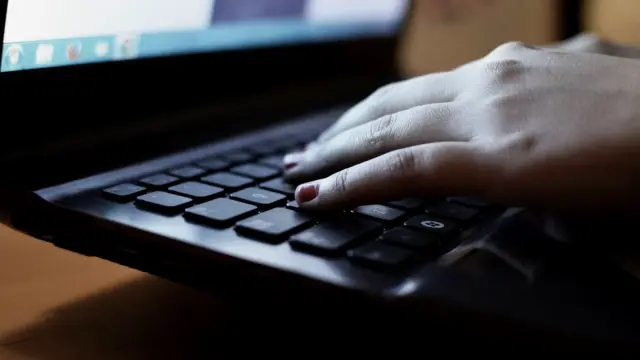 Zbliżenie na dłonie piszące na klawiaturze laptopa