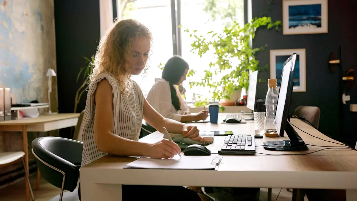 Dwie pracownice biura patrzą razem na ekran laptopa