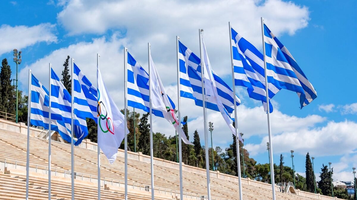 Greckie flagi powiewają na Stadionie Panathenaikos pod bezchmurnym niebem.