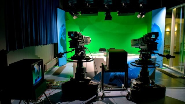 Studio telewizyjne z kamerami i zielonym tłem do realizacji nagrań.