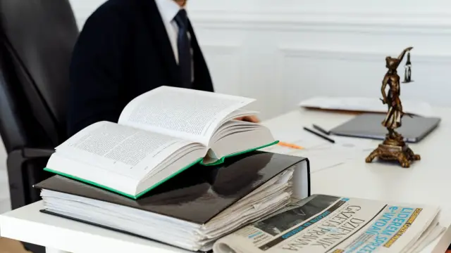 Prawnik przy biurku z otwartymi książkami i dokumentami