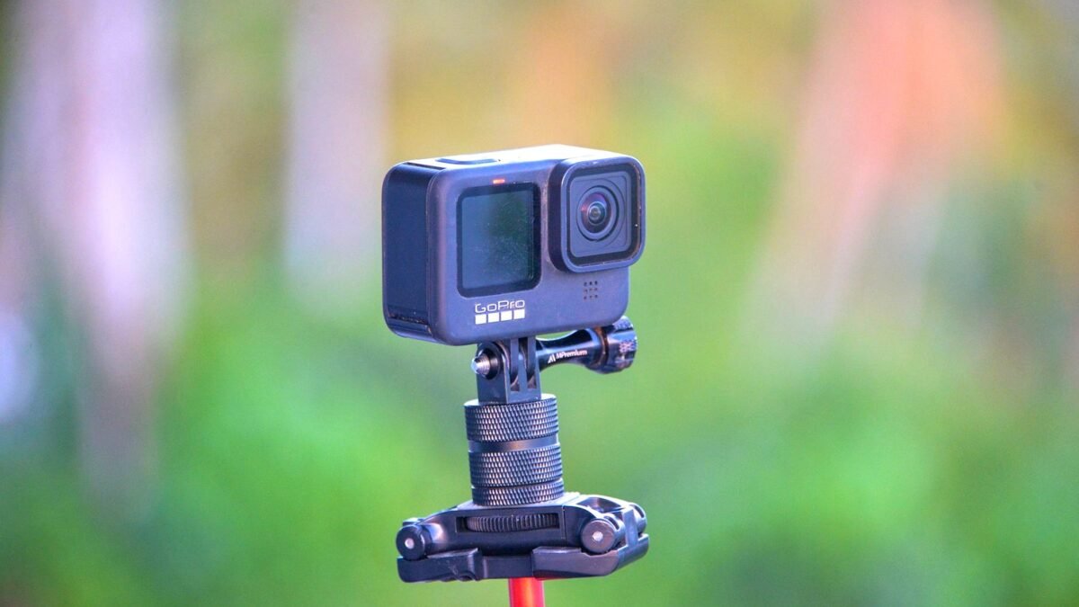 Zbliżenie kamery sportowej GoPro na statywie, w tle rozmyty plener.