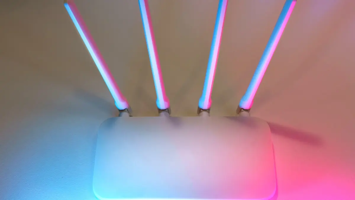 Biały router z antenami stojący na jasnym blacie w mieszkaniu