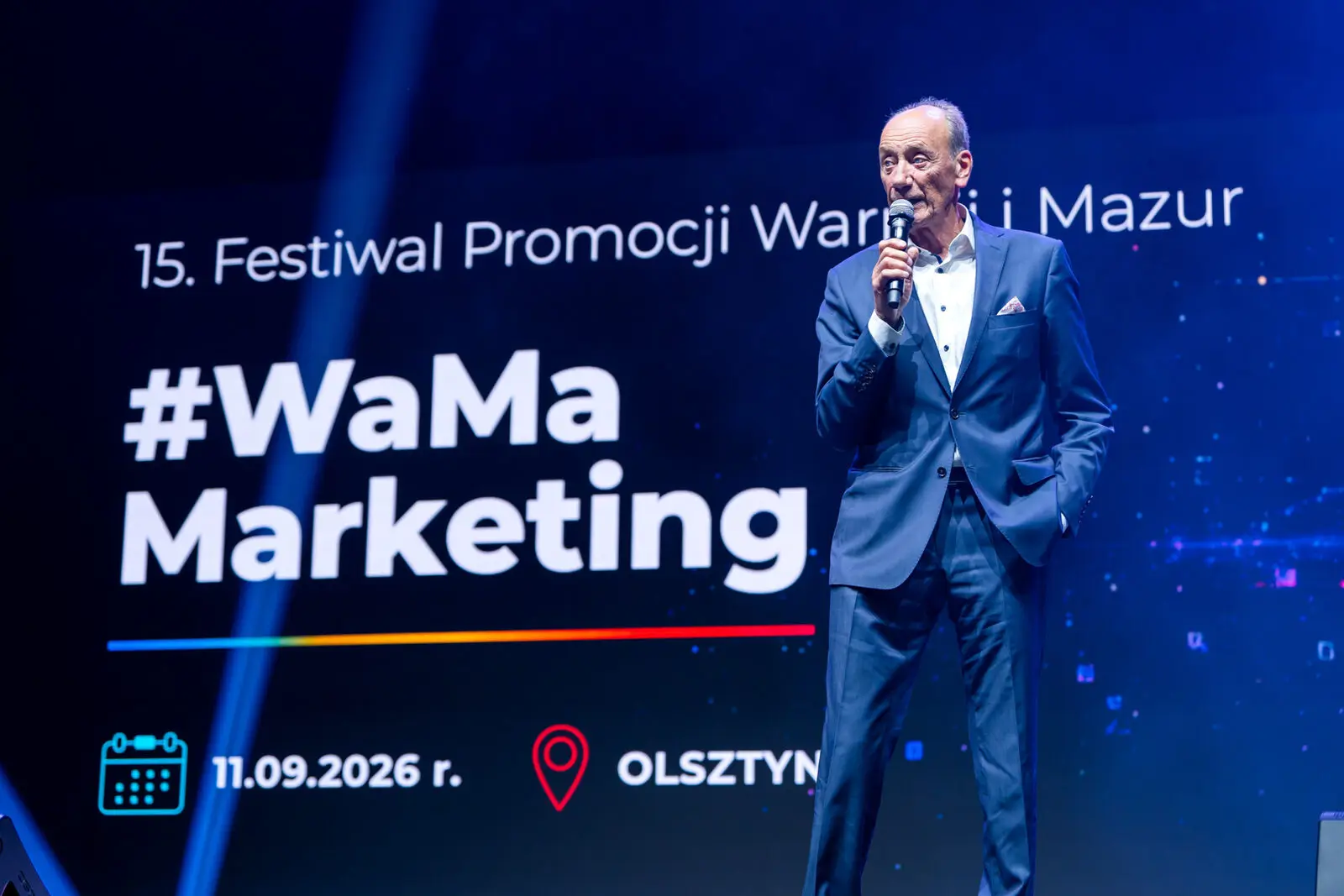 Dariusz Szpakowski z mikrofonem na Scenie Głównej konferencji #WaMaMarketing w Olsztynie