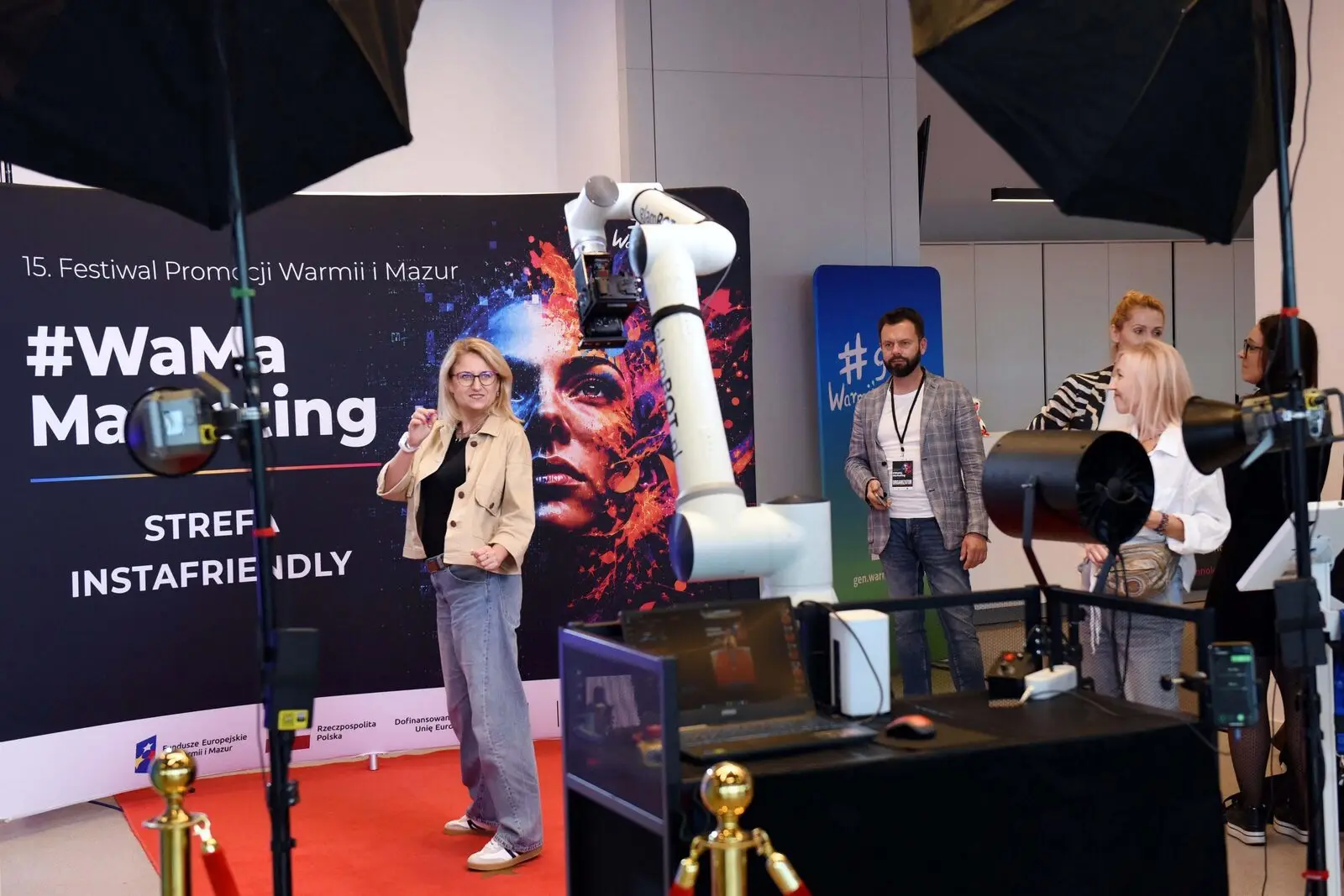 Uczestniczka konferencji #WaMaMarketing przed kamerą zamocowaną na ramieniu robota w Strefie Instafriendly