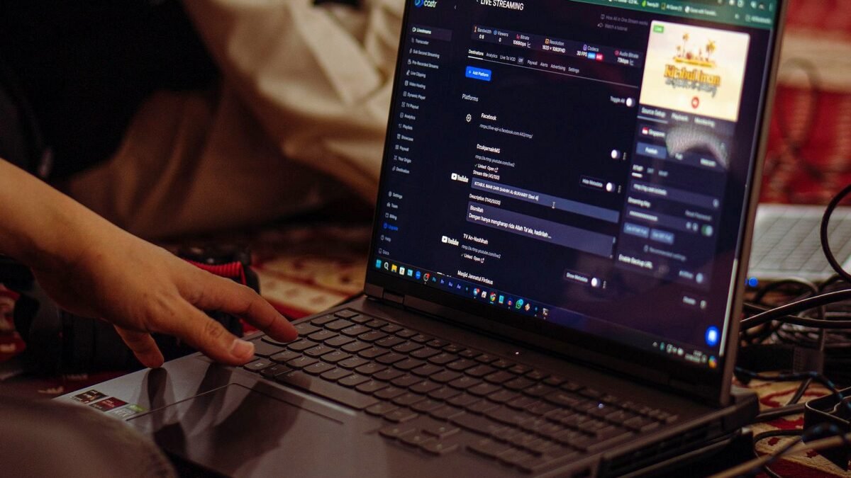 Osoba uruchamia transmisję na żywo na laptopie.