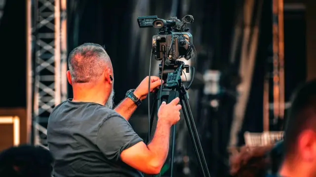Operator ustawia profesjonalną kamerę wideo przed nagraniem zdjęć.