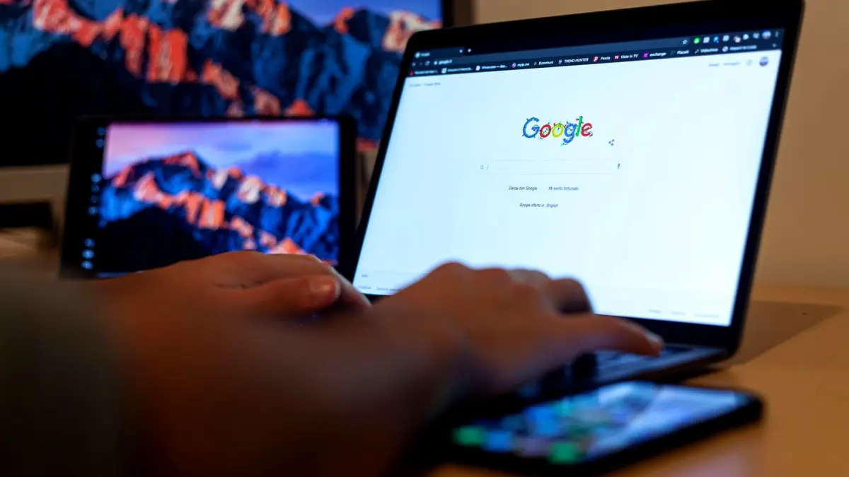 Dłonie piszą na laptopie z otwartą wyszukiwarką Google
