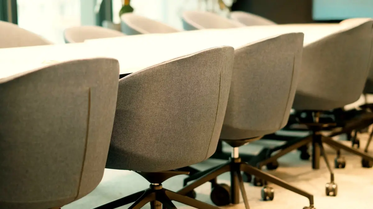 Pusta sala konferencyjna z rzędem krzeseł.