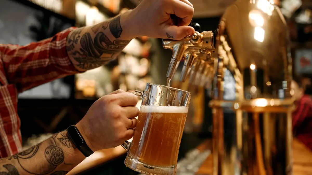 Barman nalewa piwo z kranu do kufla