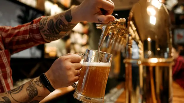 Barman nalewa piwo z kranu do kufla