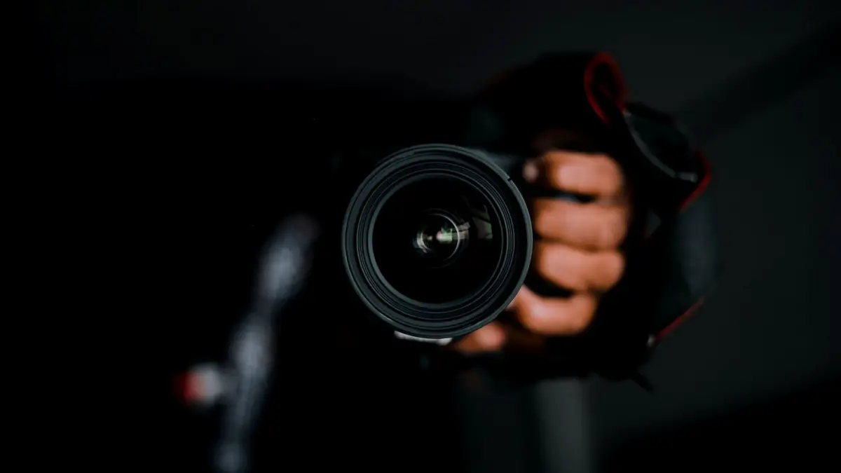 Dłoń trzymająca obiektyw aparatu fotograficznego