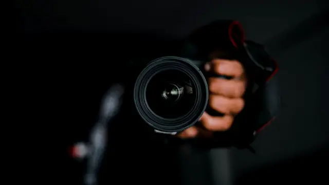 Dłoń trzymająca obiektyw aparatu fotograficznego