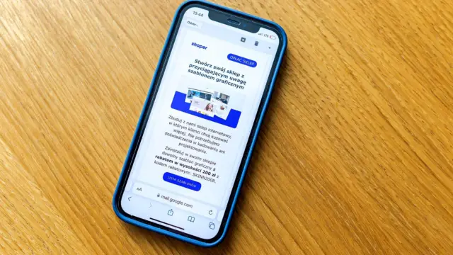 Smartfon na drewnianym stole ze stroną sklepu internetowego