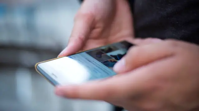 Dłonie przewijają ekran smartfona