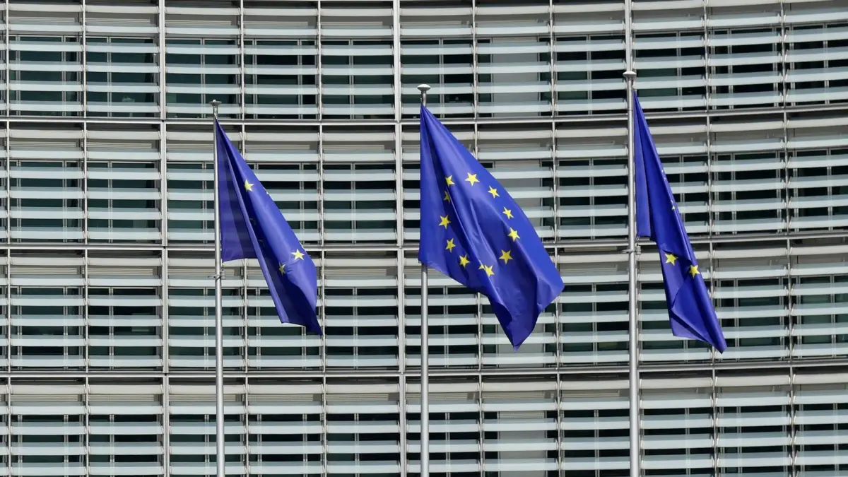 Trzy flagi Unii Europejskiej przed budynkiem Komisji Europejskiej w Brukseli