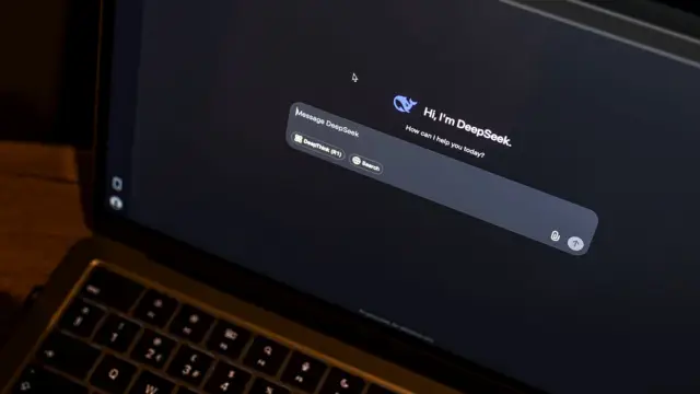 Laptop na drewnianym stole z otwartym oknem czatu z asystentem AI