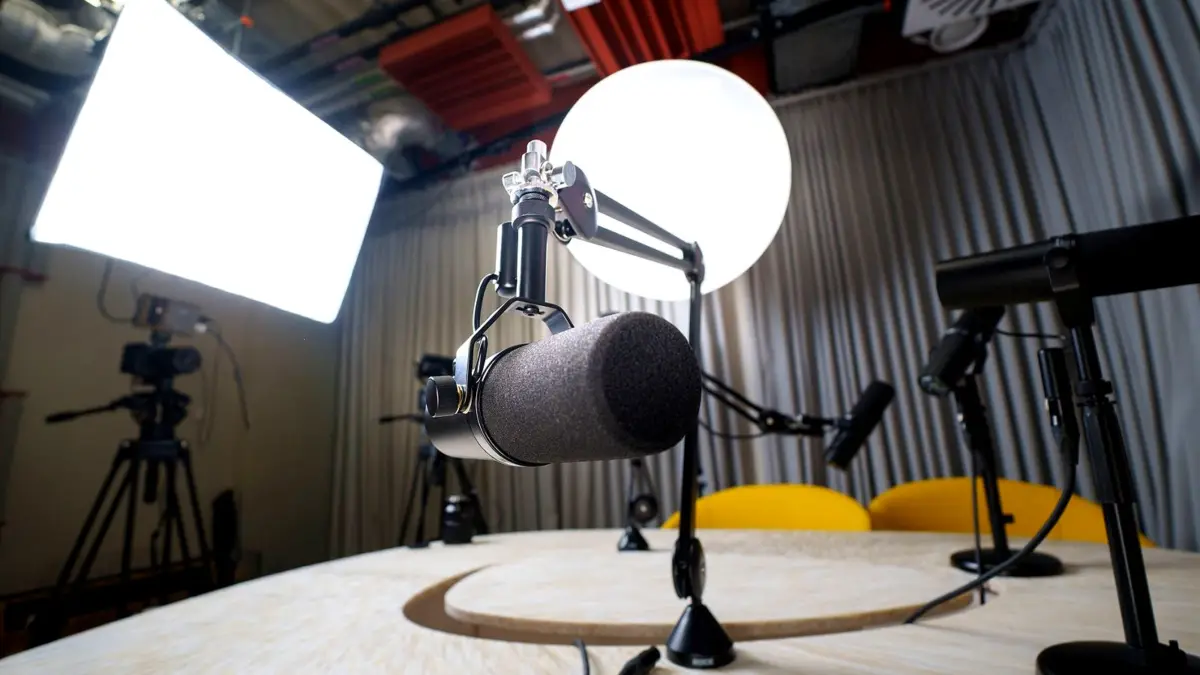 Puste studio do nagrywania podcastów z dwoma mikrofonami, krzesłami i lampami