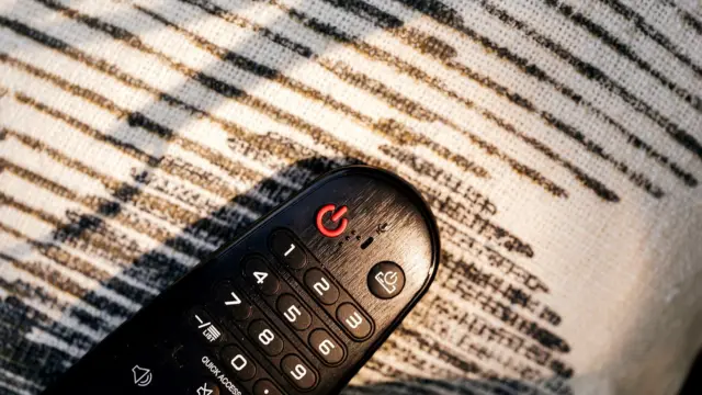 Pilot do telewizora leżący na dzianinowym kocu