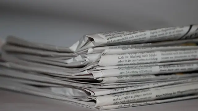 Złożone gazety leżące jedna na drugiej