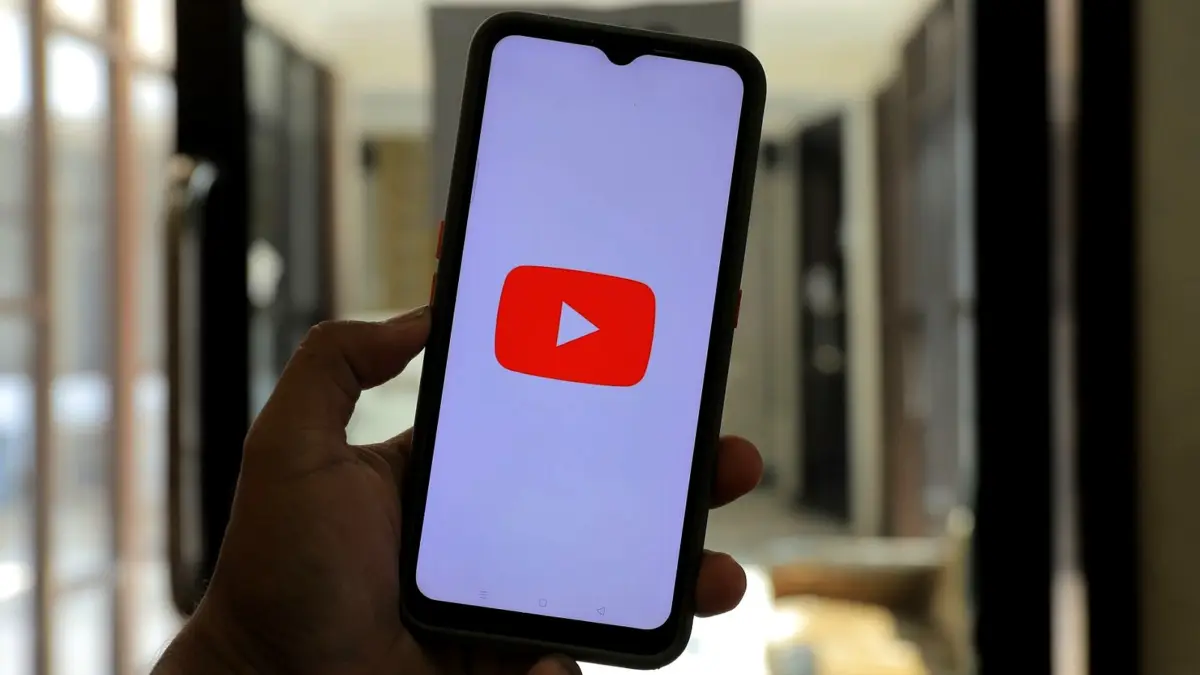Dłoń trzymająca smartfon z logo YouTube na ekranie