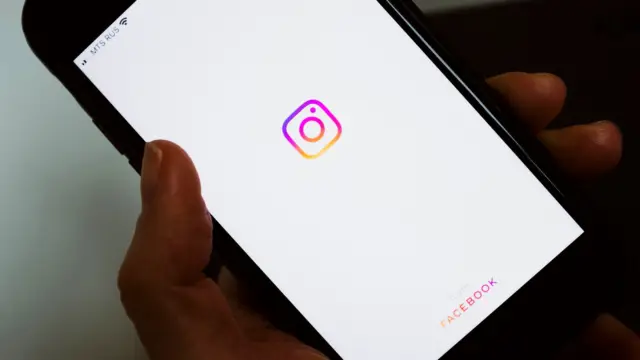 Dłoń trzyma smartfon z otwartą aplikacją Instagram