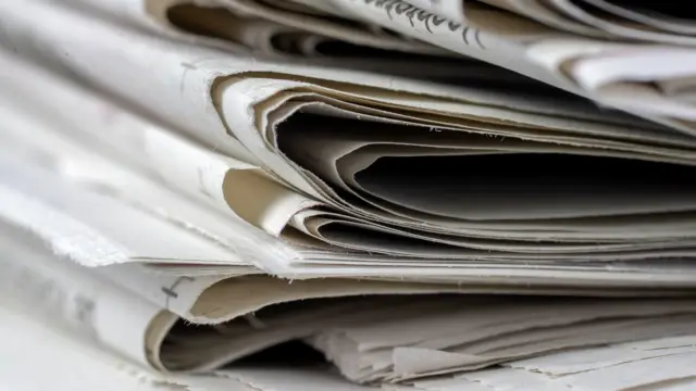 Stos złożonych gazet na stole w dziennym świetle