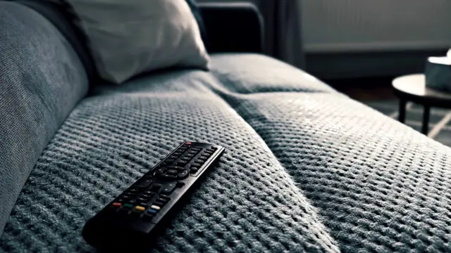 Pilot do telewizora leżący na kanapie w salonie