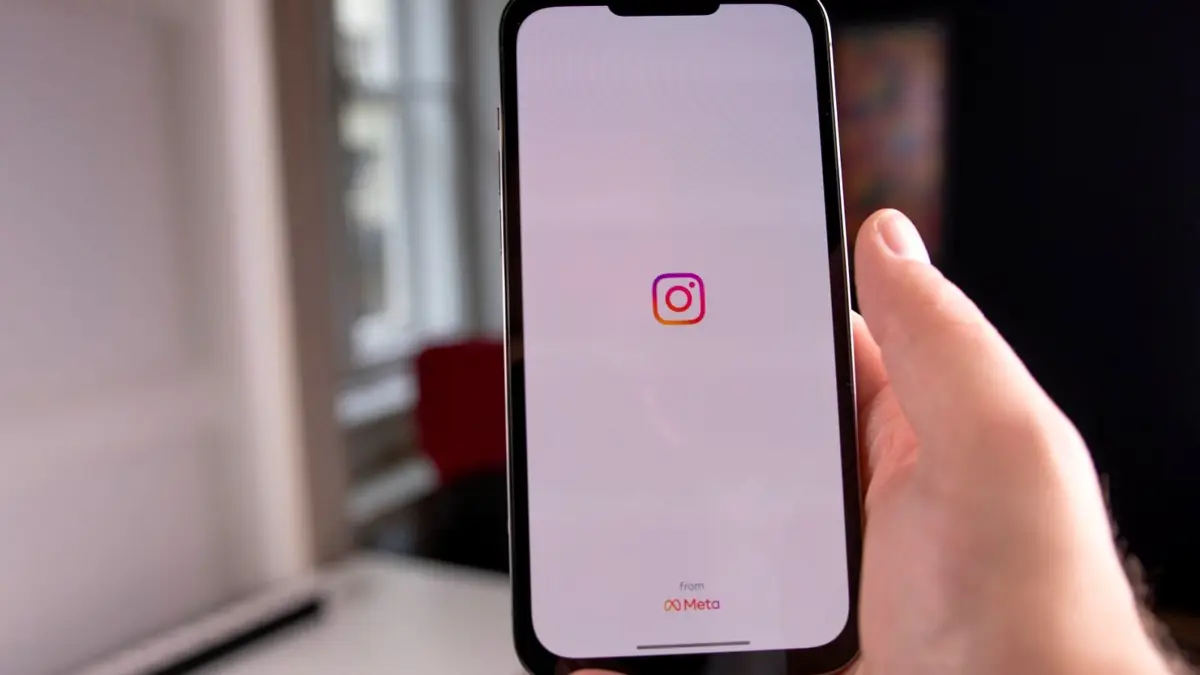 Dłoń trzyma smartfon z otwartą aplikacją Instagram