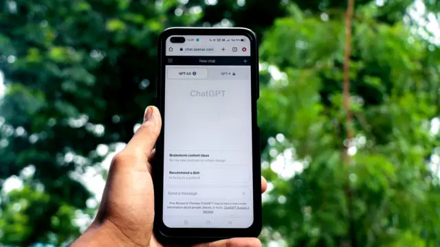 Dłoń trzyma smartfon z otwartą aplikacją ChatGPT na ekranie