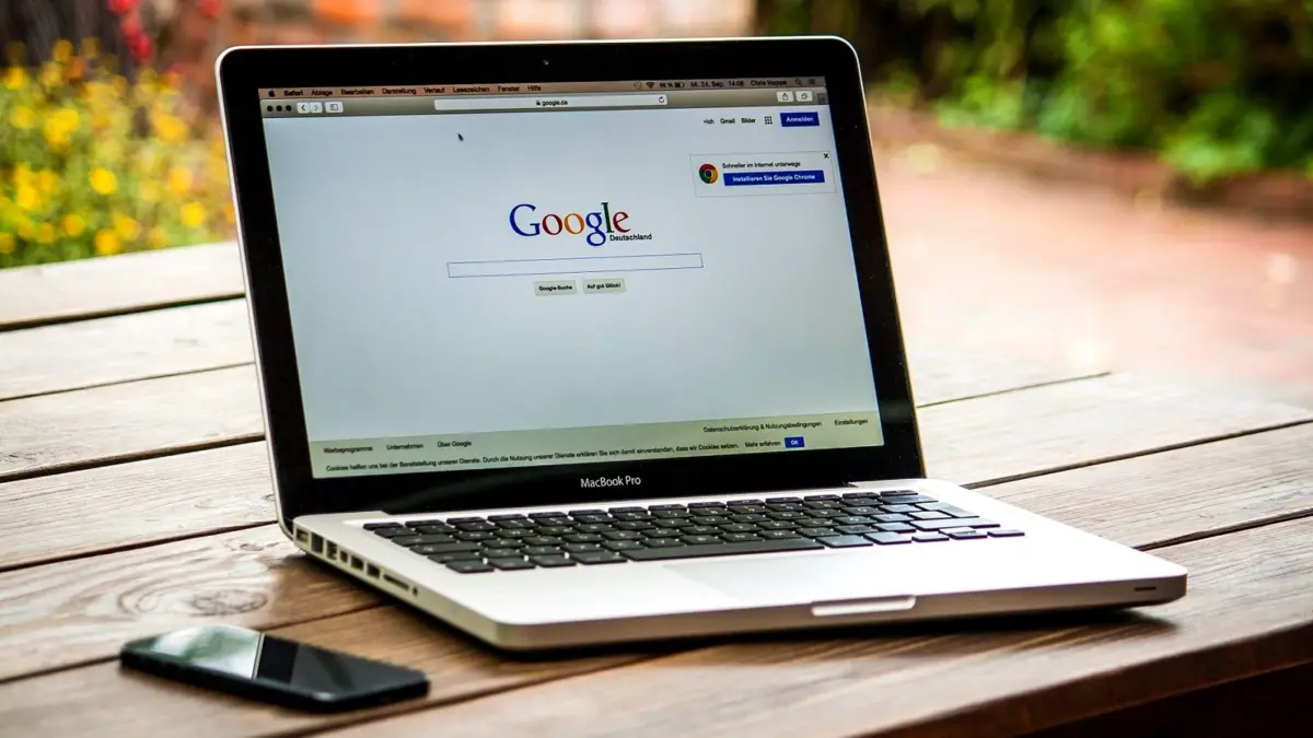 Laptop na drewnianym biurku z otwartą stroną wyszukiwarki Google