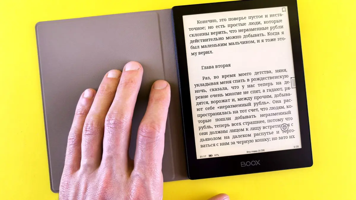 Dłoń trzyma czytnik e-booków z tekstem na ekranie