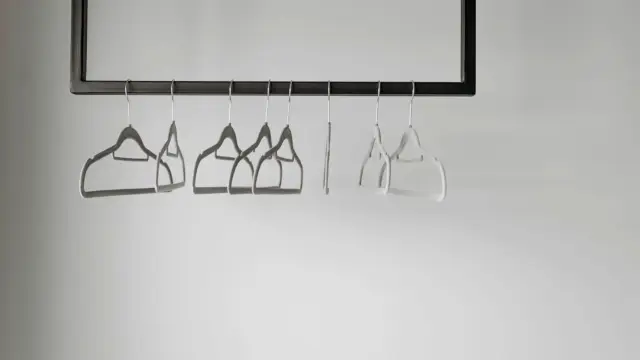 Puste wieszaki na metalowym drążku na ubrania